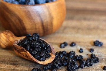 Dried Blueberries in a wooden scoop, selective focus