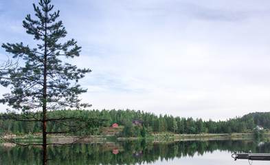 Red house and forest reflecting in lake