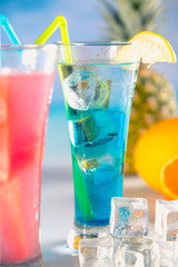 Set of exotic drinks on the beach with blue ocean background