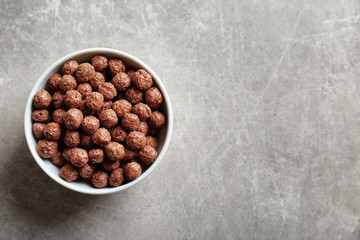 Bowl with healthy corn balls on gray background