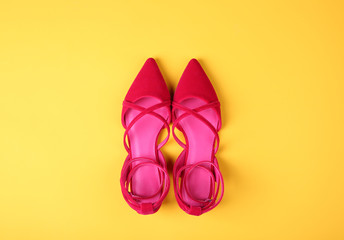 Stylish flat shoes on color background
