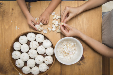 Parent and child hands to cook garlic