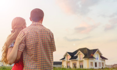 rear view of young couple looking at their new house