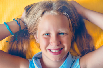 The girl smiles sincerely. blue eyes. Bracelets