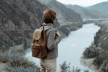 Hipster young girl with backpack enjoying mountain. Tourist traveler on background view mockup