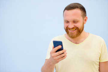 Bearded Man looking into the phone rejoices photo to advertise a lot of space under the text