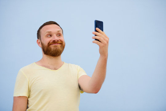 man makes faces in a funny and humorous phone shows a language, an advertising company