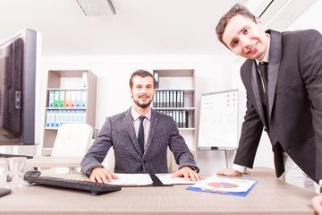 Businessmans at the desk working in formal suits working in office. Teamwok and meetings. Professional communication