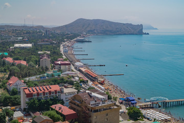 Naklejka premium View of the seaside town Sudak in Crimea with coast, pier and sea