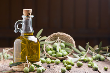 Olive oil and olives on wooden rustic table