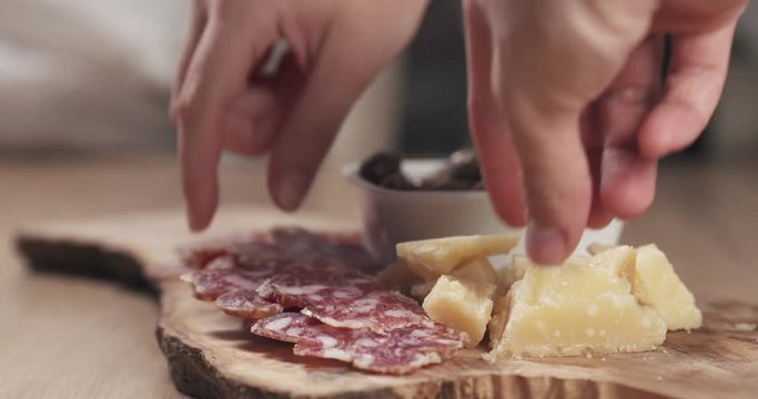 slow motion slide shot three hands taking italian antipasti appetizers from table