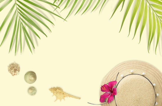 Beach accessories  with tropical leaves frame on soft yellow background. Summer beach concept