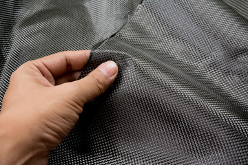 Black carbon fiber composite raw material close up background