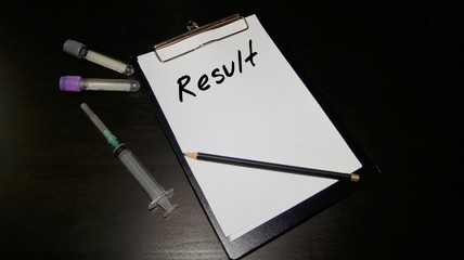 Notepad with blood sample bottle and syringe with word result