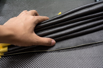 Black carbon fiber composite raw material close up background