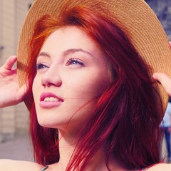 Sexy Red hair girl portrait. Girl in hipster hat posing in front of camera. Pretty girl looking at...