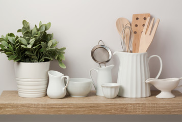 Fototapeta na wymiar Kitchen utensils and dishware on wooden shelf.