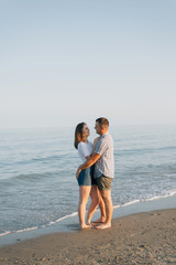 On the seashore, embracing, there is a loving couple