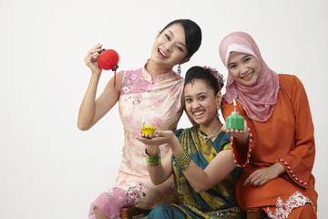 three malaysian woman holding lamp