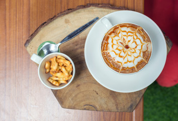white coffee latte art on wood table in cafe, top view