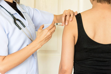 doctor woman giving a woman injection in arm