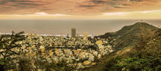 Panoramic view of the vietnamese city Vũng Tàu and statue of Jesus on a hill on the sunset