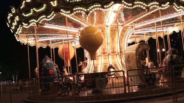 Beautiful classic carousel all in the lights, revolving in a night park.