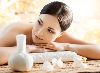 Young and beautiful girl relaxing in spa salon. Massage therapy over seasonal autumn background....