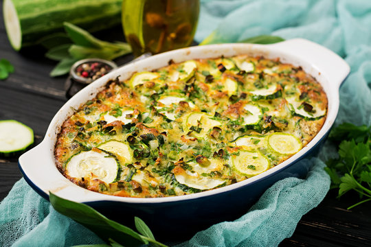 Zucchini casserole with eggs, milk, cheese and greens herbs