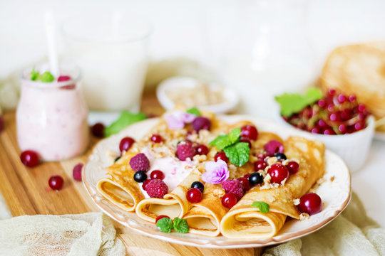 Pancakes with yoghurt, honey, nuts and summer berries. Tasty breakfast.