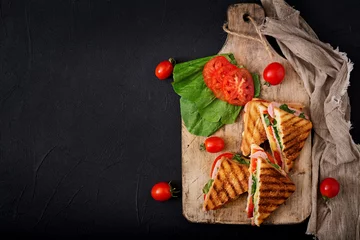 Zelfklevend Fotobehang Club sandwich panini with ham, tomato, cheese and basil. Flat lay. Top view © timolina