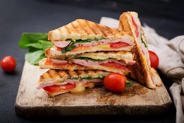 Fototapeten Club sandwich panini with ham, tomato, cheese and basil. © timolina