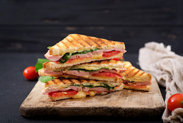 Club sandwich panini met ham, tomaat, kaas en basilicum.