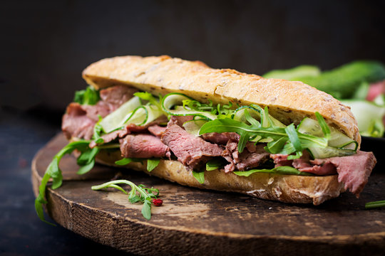 Sandwich of whole wheat bread with roast beef, cucumber and arugula