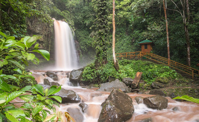 Scenic view of waterfall in the jungle. Long exposure shot. Smooth water jets falling down on stones. Mahua waterfall, Borneo island, Sabah, Malaysia