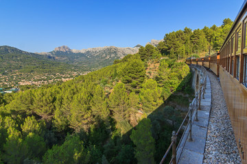 Crossing a viaduct on board a train between Soller and Palma with views over the village of Soller and the mountains range of the Serra de Tramuntana, Majorca Balearic Islands