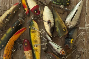 Foto op Canvas Wet antique fishing lures viewed from above on a rough wood surface © Daniel Thornberg