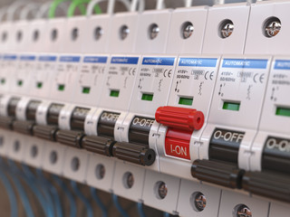 Switches in fusebox. Many black circuit brakers in a row in position OFF and one red switch in position ON.