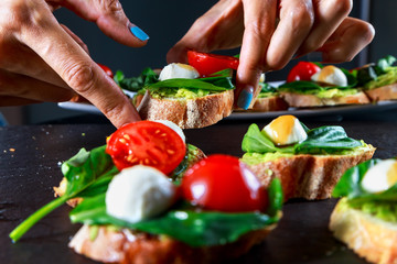 tapas with avocado, boiled quail eggs and Basil with teriyaki sauce on a black granite surface table