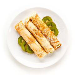 Crepes with kiwi and cream on white background 