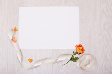Creative mock up layout made of roses  with copy space on table homemade flat lay. Empty sheet of paper. Mockup with a card and orang rose
