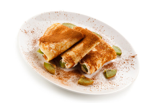 Crepes with kiwi and cream on white background 