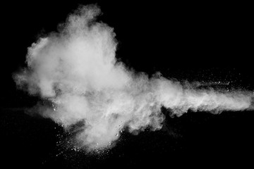 Freeze motion explosion of white dust on a black background.Stopping the movement of white powder on dark background.