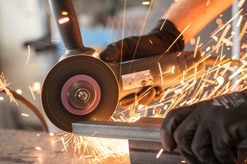 Electric wheel grinding on steel structure in factory