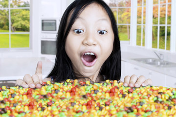 Child with candies in kitchen