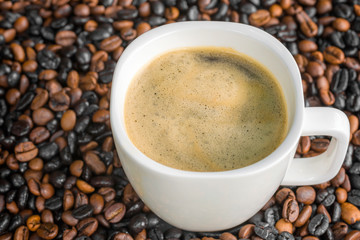 Tasse Kaffee mit Bohnen im Hintergrund