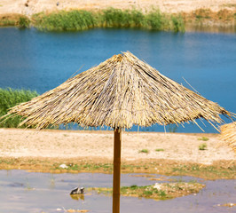 Straw sun umbrella on the beach