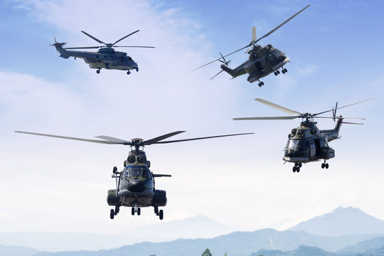 Four military helicopters flying in the blue sky