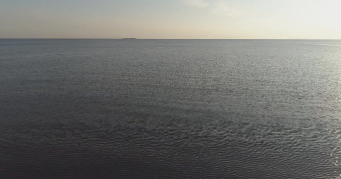 Aerial forward tilt fly over baltic sea in bright sunset time