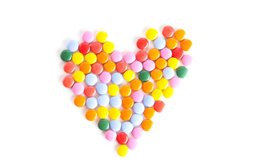 Heart shape made from colorful button-shaped candies 
